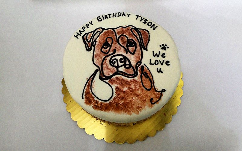 round birthday cake features a realistic dog illustration with happy birthday tyson